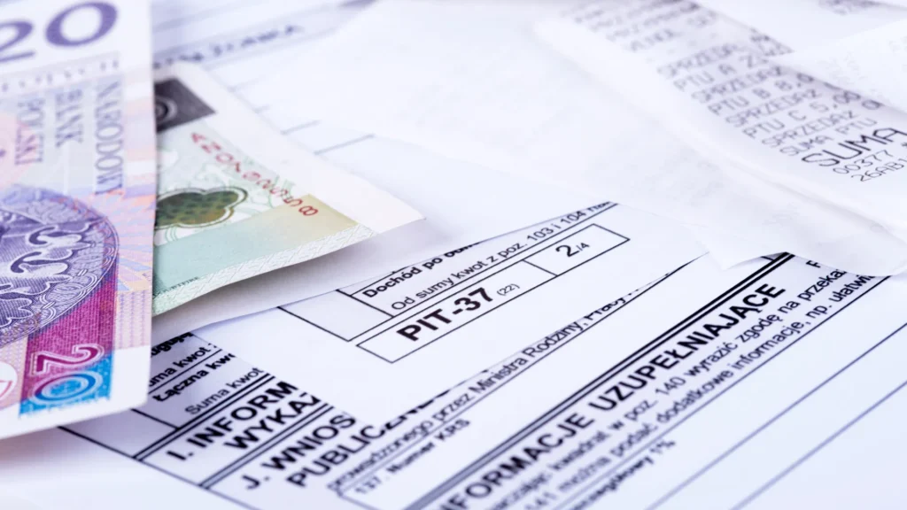 rozliczanie PIT dokumenty i gotówka na biurku